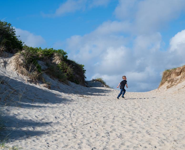 Barn løber i sandet